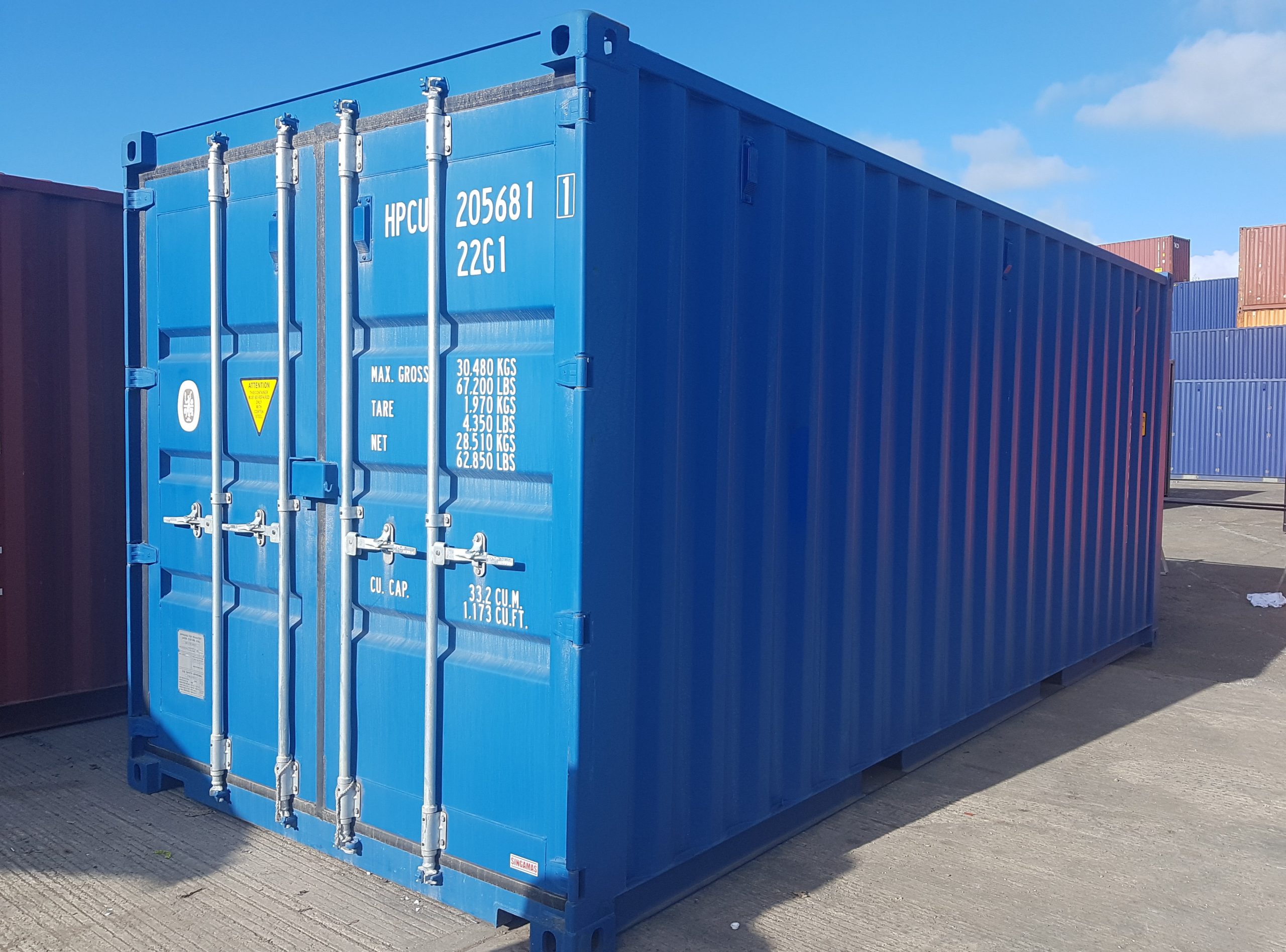 A blue shipping container outside on a clear, sunny day.