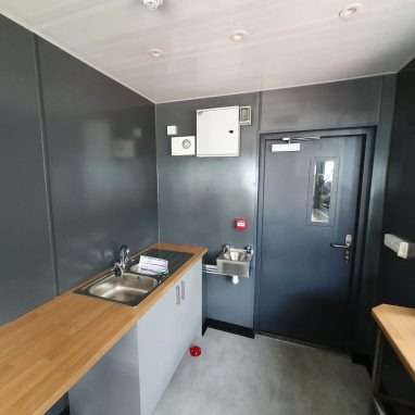 Interior view of container coffee shop with in-built countertops and sink area.