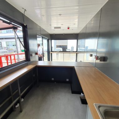 Interior view of container coffee shop with in-built countertops and sink area.